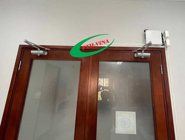 lắp tay co thủy lực trên 2 cánh cửa